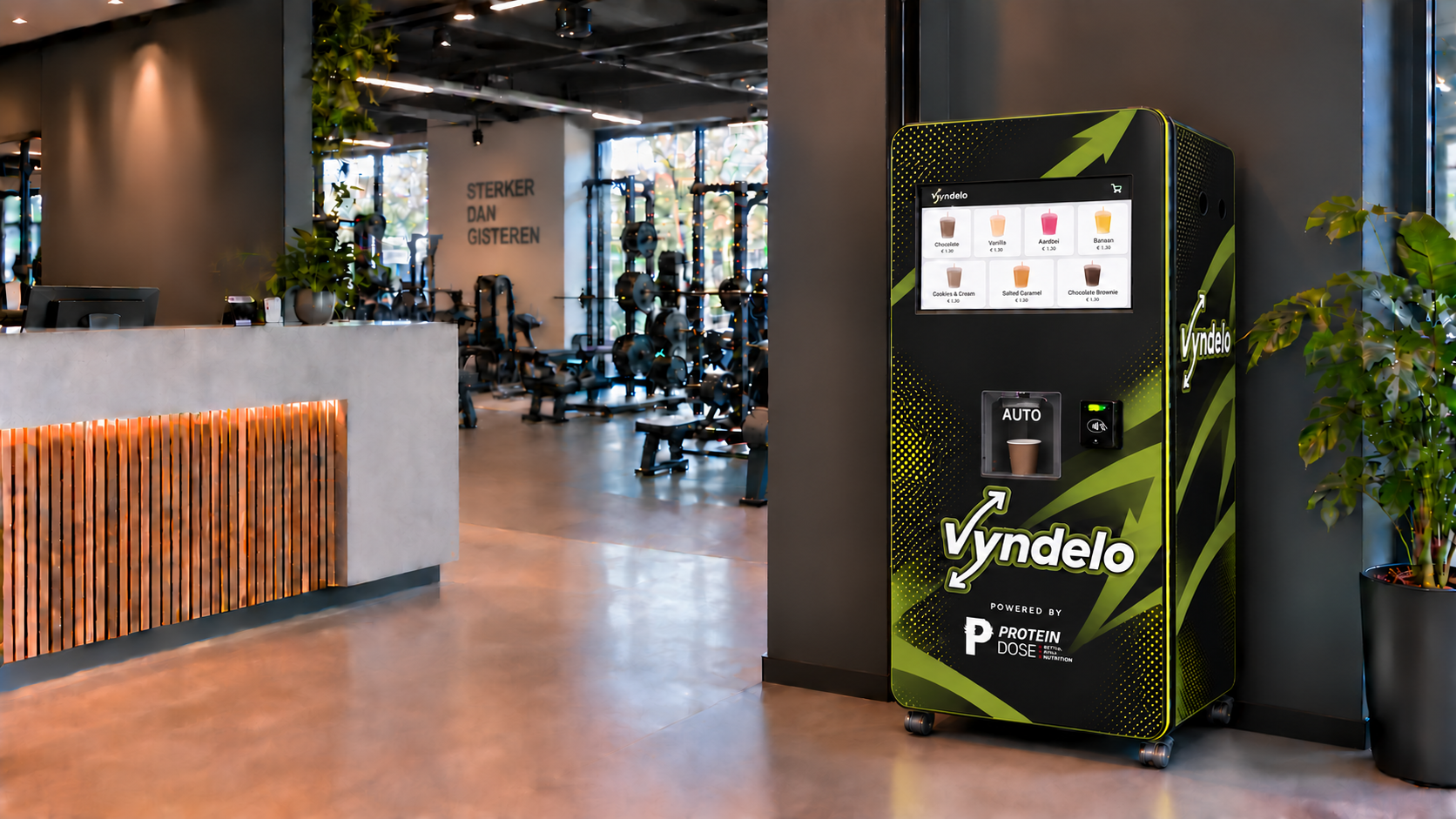 Vyndelo-proteïneshakeautomaat met het nieuwe zwart-groene ontwerp en betaalautomaat in de oorspronkelijke sportschoolfoto